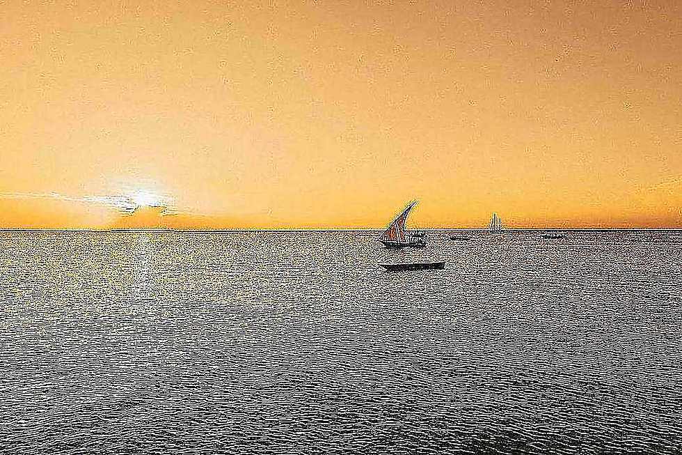Traditional dhow sailing at sunset off Zanzibar